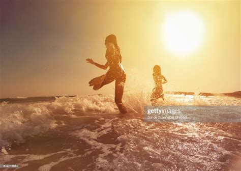 Happy Girls Running To The Sea On A Beautiful Sunset Photo Getty Images