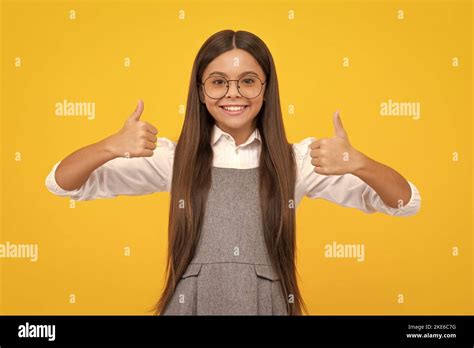 Optimistic Cool Teenager Child Girl With Thumb Up Isolated On Yellow