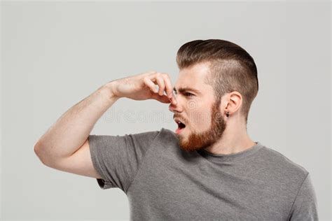 Young Handsome Man Pinching Nose Over Grey Background Copy Space
