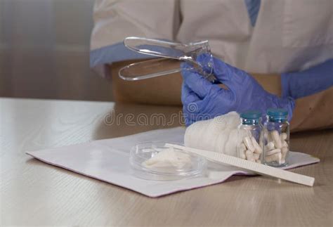 Glass Bottles With Pills In Front Of Gynecologist Who Keeps Vaginal Speculum Closeup Stock