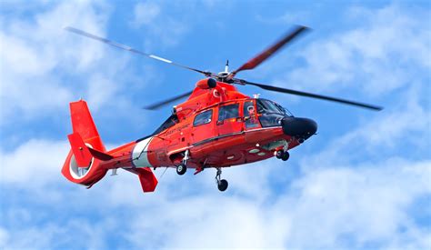 Red Rescue Helicopter Moving In Blue Sky White Rose Aviation