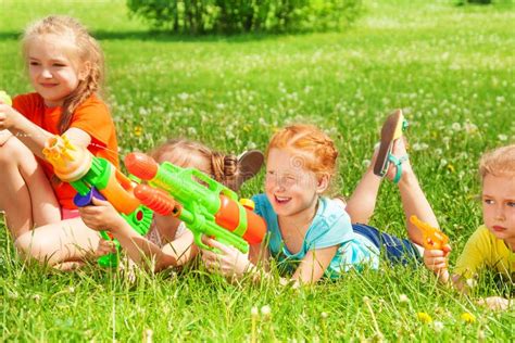 Children Play With Water Guns On A Meadow Stock Image Image Of Blonde