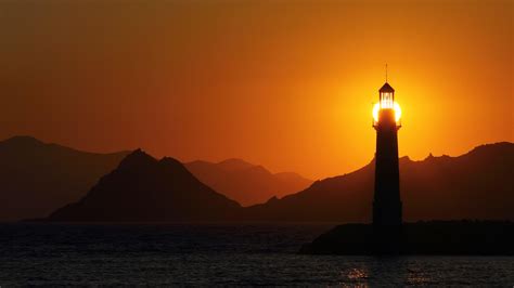 Seascape At Sunset With Lighthouse On The Coast Seaside Town Of