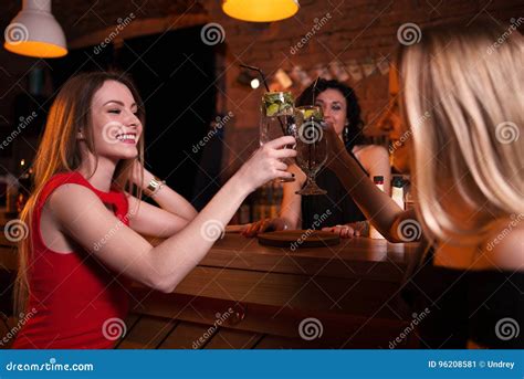 Deux Filles Assez Caucasiennes Grillant Les Cocktails Potables Dans Le Bar Célébrant L