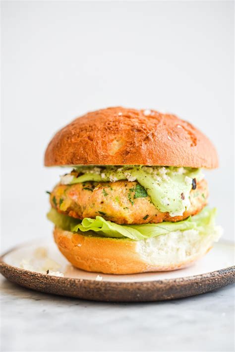 A Salmon Burger On A Bun With Lettuce And Green Goddess Dressing Salmon