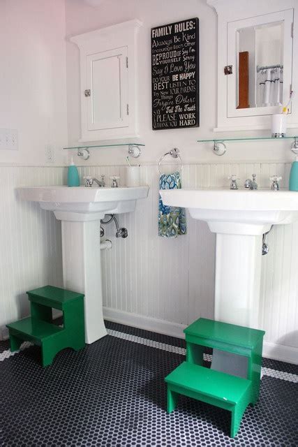 Two Stand Alone Sinks In The Kids Bathroom With Step Stools In Green