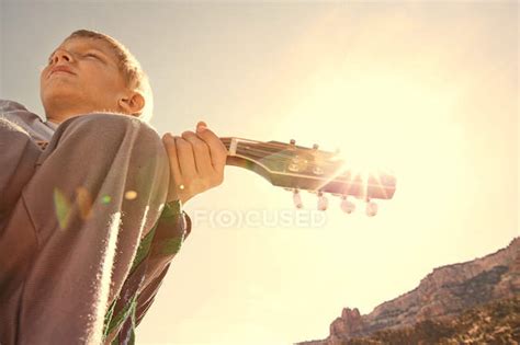 Boy Playing Guitar Outdoors — Little Solar Flare Stock Photo