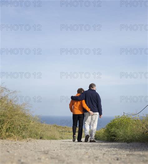 caucasian couple walking on beach photo12 tetra images sam diephuis