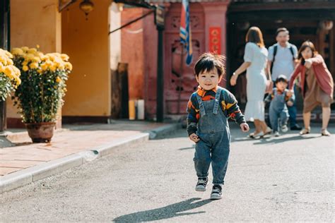 Happy Ethnic Toddler Running Away From Parents During Walk In Park