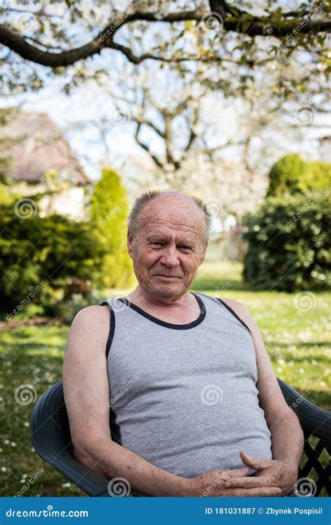 Portrait Of Happy Senior Man Sitting In Chair At His Garden Stock Image