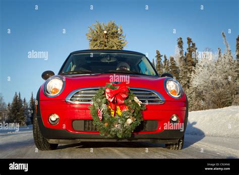 Mini Cooper Sports Car With Christmas Tree On Top Along Rural Road