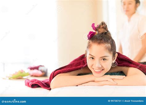 a menina asiática está sorrindo na cama tailandesa dos termas da massagem imagem de stock