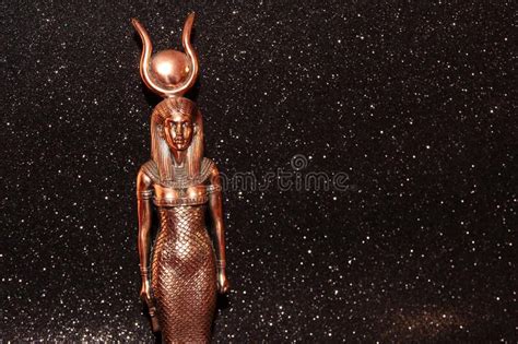 The Egyptian Goddess Isis On A Black Background A Bronze Egyptian Goddess With A Circle On Her