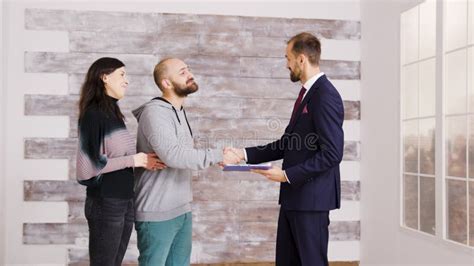 Real Estate Agent In Business Suit Giving Keys To Young Couple Stock Image Image Of Couple