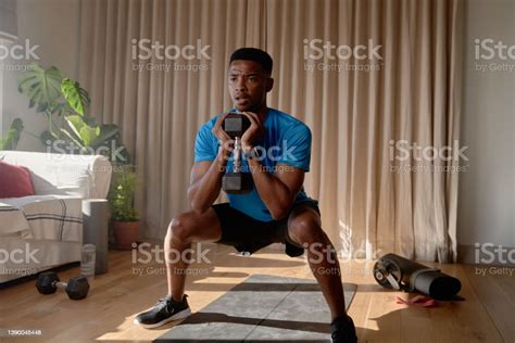 Young African American Male Concentrating While Squatting With A