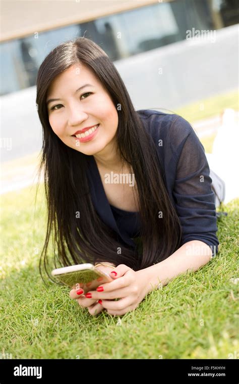 Japanese Girl In The Park Holding Her Mobile Phone Stock Photo Alamy