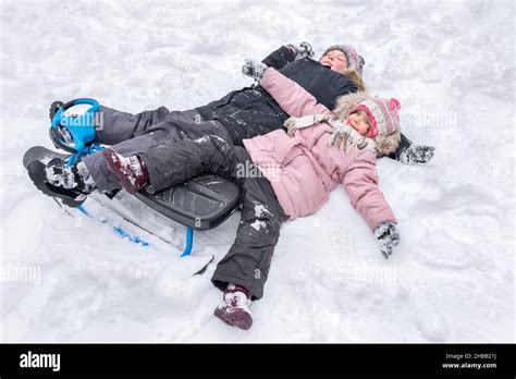 A Happy Boy And Girl Lying Together In The Snow Making Snow Angels