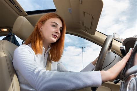 Premium Photo Wide Angle View Of Young Redhead Woman Driver Fastened By Seatbelt Driving A Car