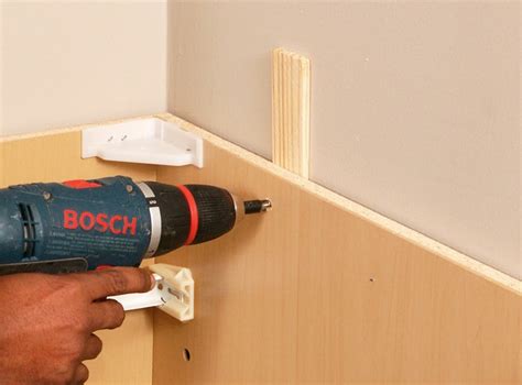 Use clamps to fix the stiles (the vertical pieces on the face of the cabinet frames) of the cabinets together and check for plumb, making sure the fronts of the cabinets are flush. How to Install Kitchen Cabinets | HomeTips