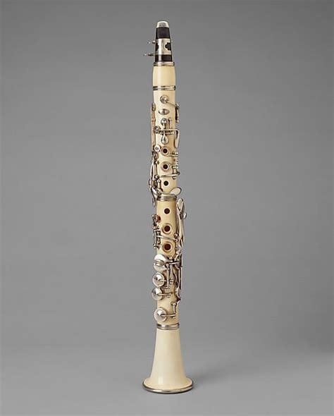An Ivory And Black Flute With Metal Decorations