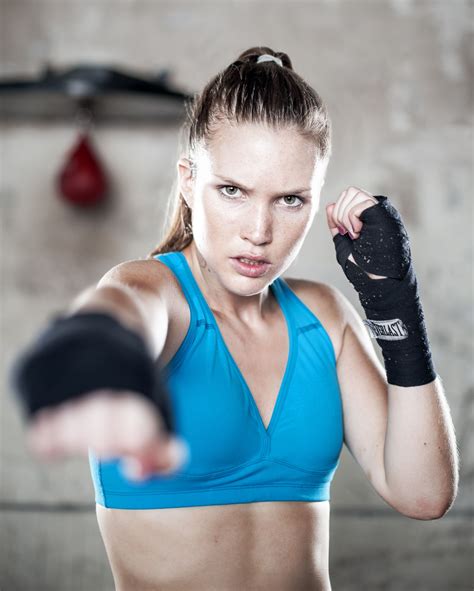 A Woman In A Blue Top Holding A Boxing Glove