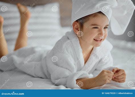 Cheerful Caucasian Little Girl Wearing White Towel On Head After Shower