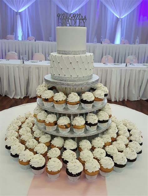 A Wedding Cake And Cupcakes On A Table