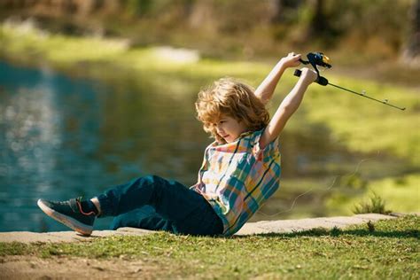 Premium Photo Boy With Fishing Rod At River Little Fisher On The Lake