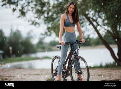 Young Pretty Woman Female Cyclist With Good Body Shape Standing With Her Bike On Beach At