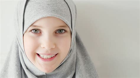 Young Muslim Teen Girl In Hijab Shyly Looking At Camera And Smiling