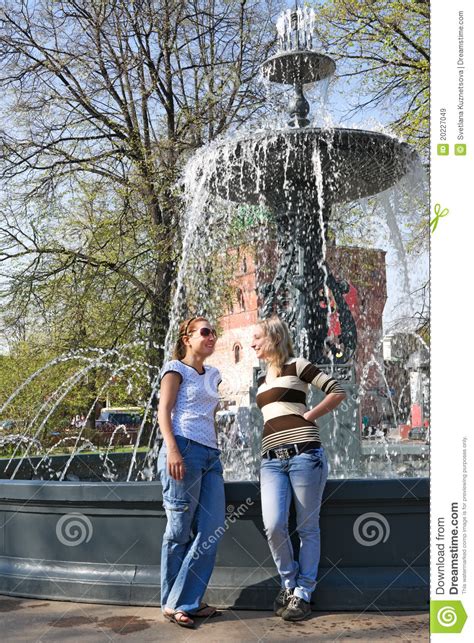 Two Friends Chatting Merrily At The City Fountain Stock Image Image