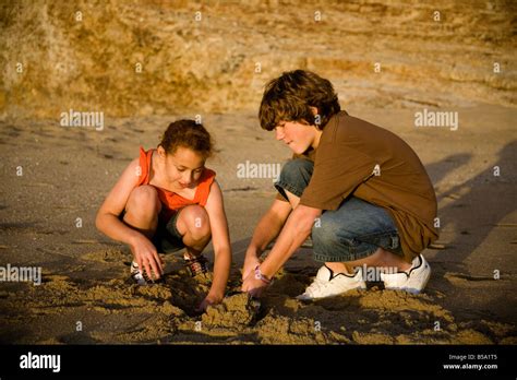 Kids Digging In The Sand On The Beach Stock Photo Alamy