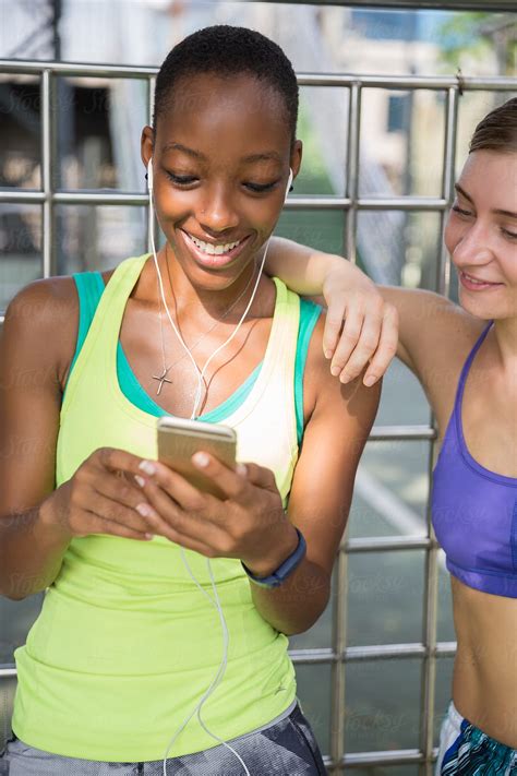 Two Attractive Female Runners Looking At The Phone Planing Their Running Training By Jovo Jovanovic