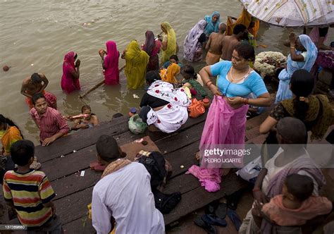 An Indian Woman Changes Her Clothes After Bathing In The Banks Of The