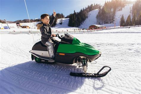 Boy Driving Snowmobile In A Winter Landscape Outdoor Troop
