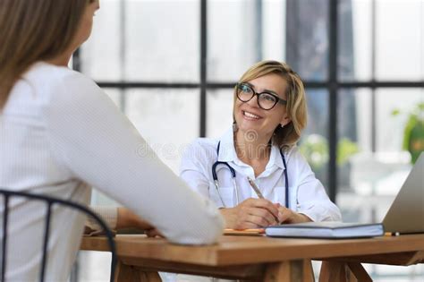 Middle Aged Female Doctor Therapist In Consultation With Patient In