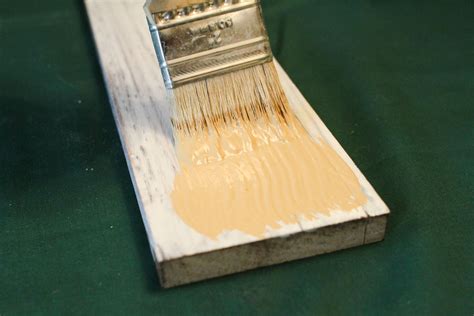 A Paint Brush Is Being Used To Paint A Piece Of Wood With Yellow And