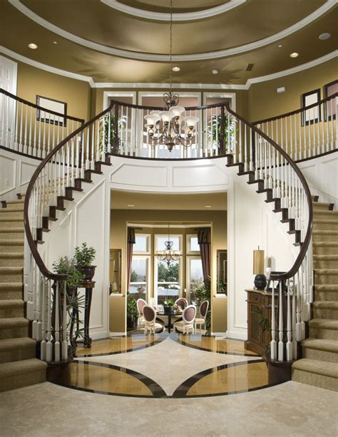 A Large Foyer With Stairs And Chandelier