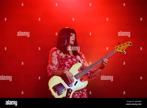 Bassist Laura Lee Of Khruangbin On Stage Wearing A Red Floral Mini