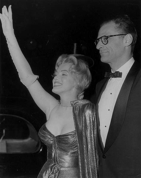 An Old Black And White Photo Of Two People Dressed In Formal Wear One Holding Her Arm Up
