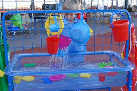 Sand And Water Activity Frame Being Used In Early Years Exploring With
