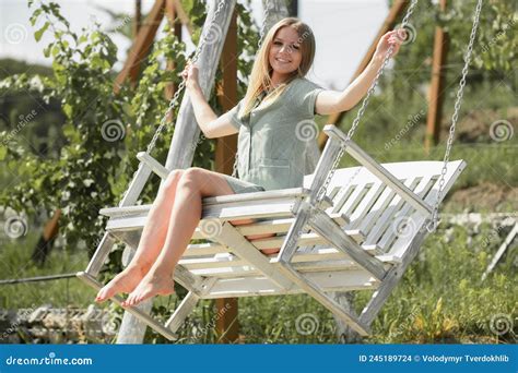 Blonde Woman On A Swing During Summer Vacation Portrait Of Attractive