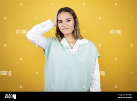 Pretty Young Woman Standing Over Yellow Background Putting One Hand On