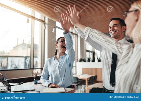Laughing Coworkers High Fiving Together In An Office Stock Image