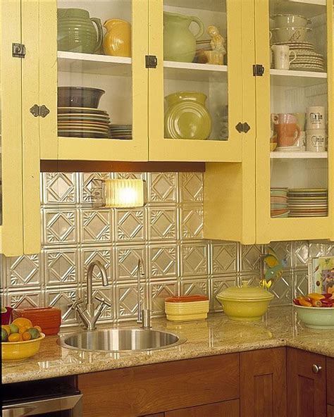 A cottage kitchen needs a fitting backsplash for its cozy character. Yellow cabinets and tin backsplash | Bungalow kitchen, Vintage kitchen, Home