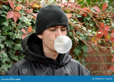 Portrait Of A Young Man He Blows A Bubble With Chewing Gum Stock Photo