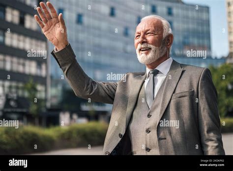 Happy Senior Businessman Waving While Hailing For Cab Elderly Male