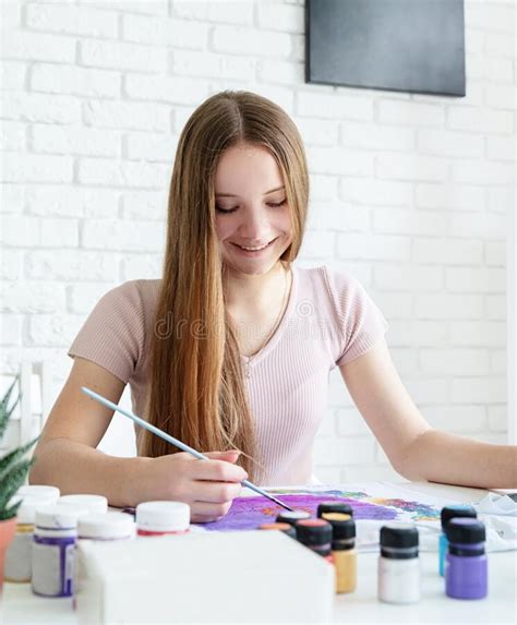 Smiling Woman Artist Painting On Clothes In Her Studio Stock Image