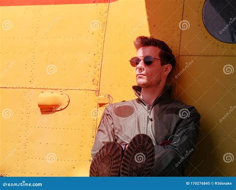 A Handsome Young Pilot Sitting On The Wing Of A Plane Stock Image