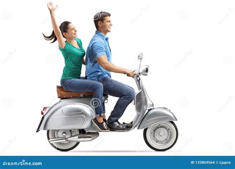 Young Couple Riding On A Vintage Motorbike And Waving Stock Photo
